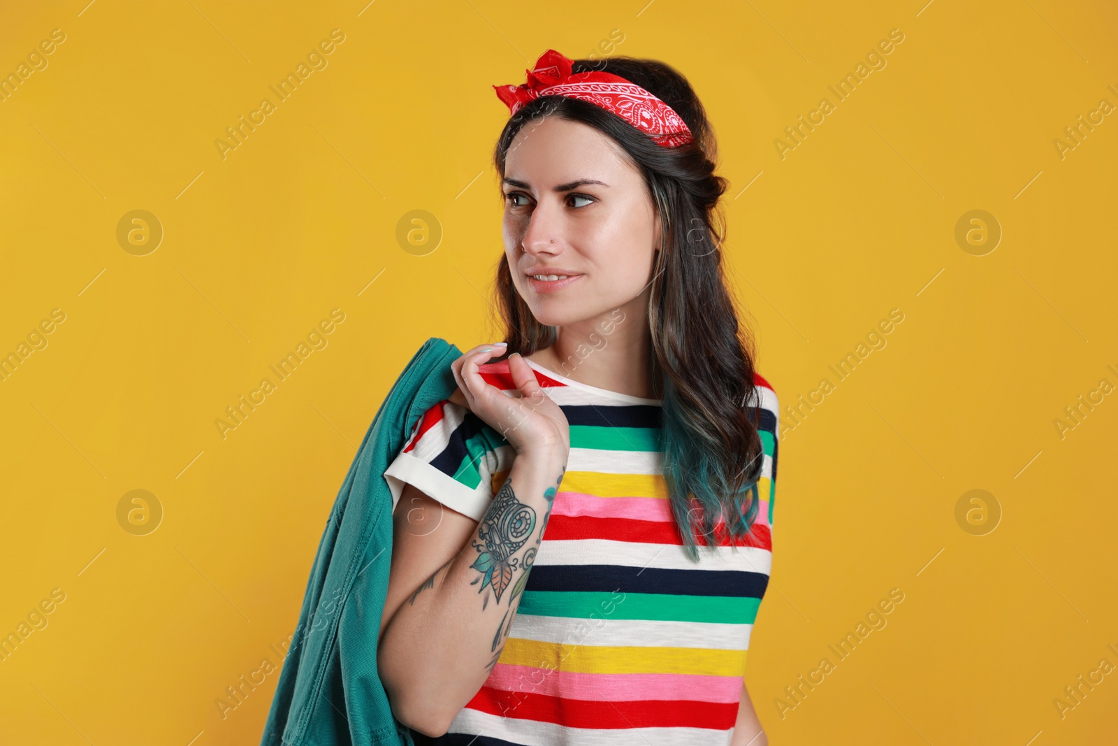 Photo of Beautiful young woman with nose piercing on yellow background