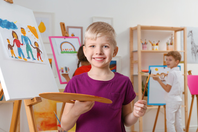 Photo of Cute little child painting during lesson in room