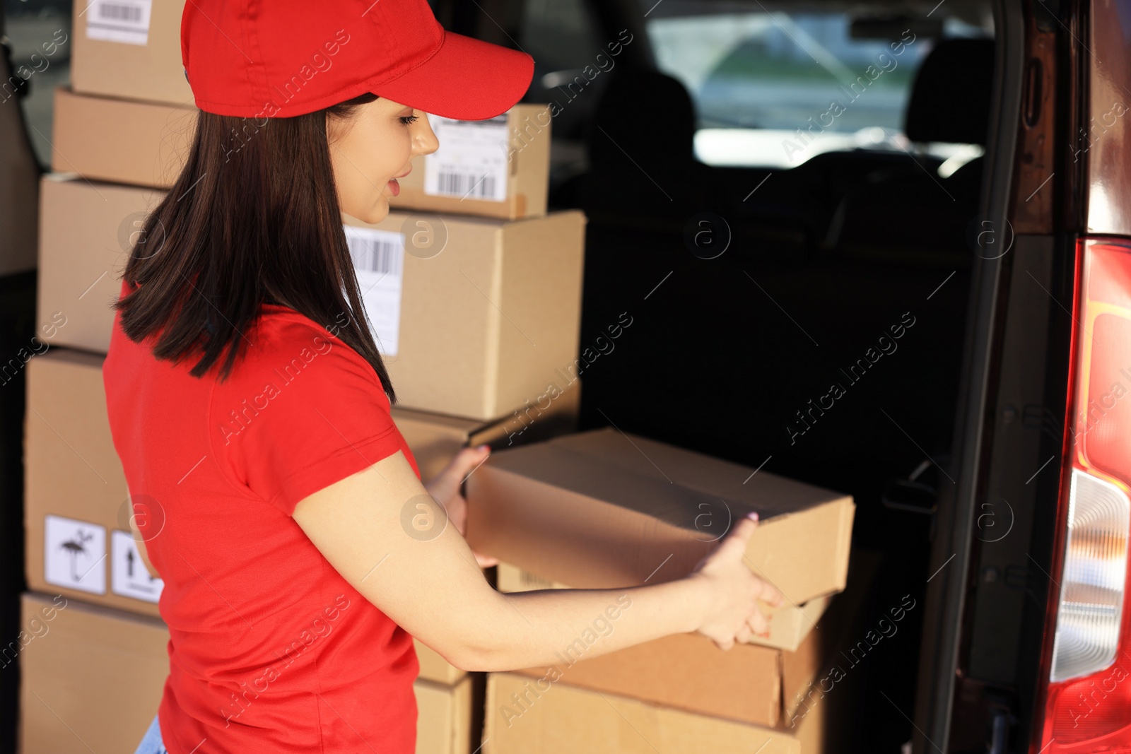 Photo of Courier taking parcel from delivery van outdoors