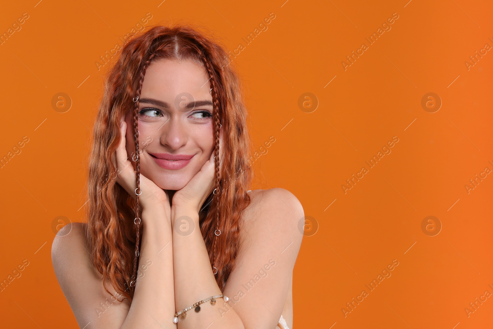 Photo of Beautiful young hippie woman on orange background, space for text