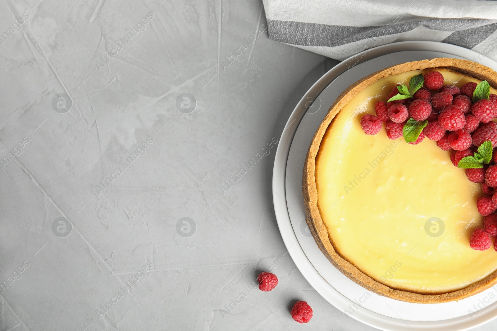 Photo of Dessert plate with delicious raspberry cake on grey table, flat lay. Space for text