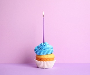 Photo of Birthday cupcake with candle on violet background