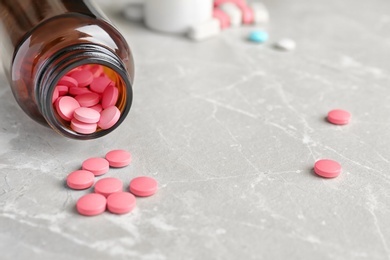 Bottle with pills on light background