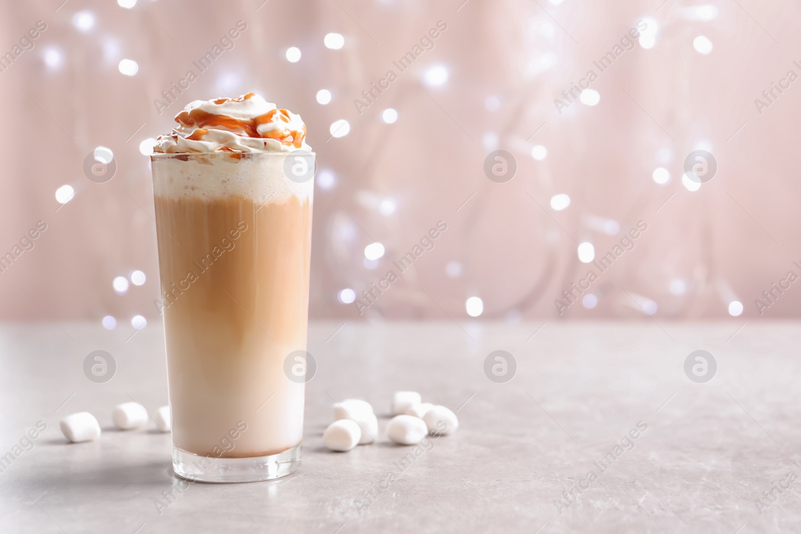 Photo of Glass with delicious caramel frappe on table