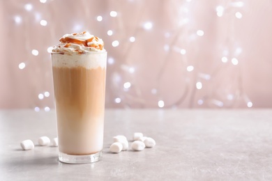 Photo of Glass with delicious caramel frappe on table