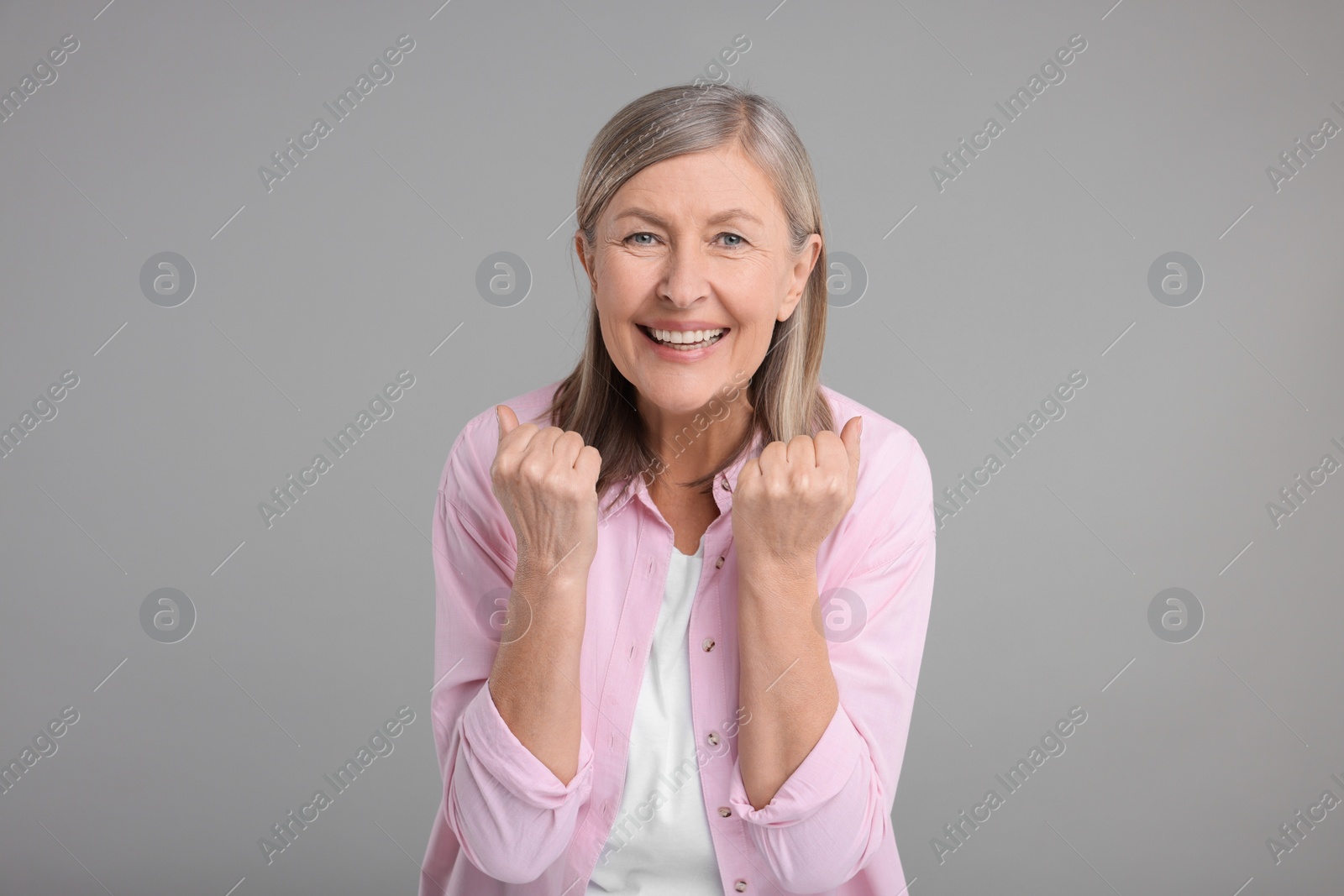 Photo of Portrait of happy surprised senior woman on grey background