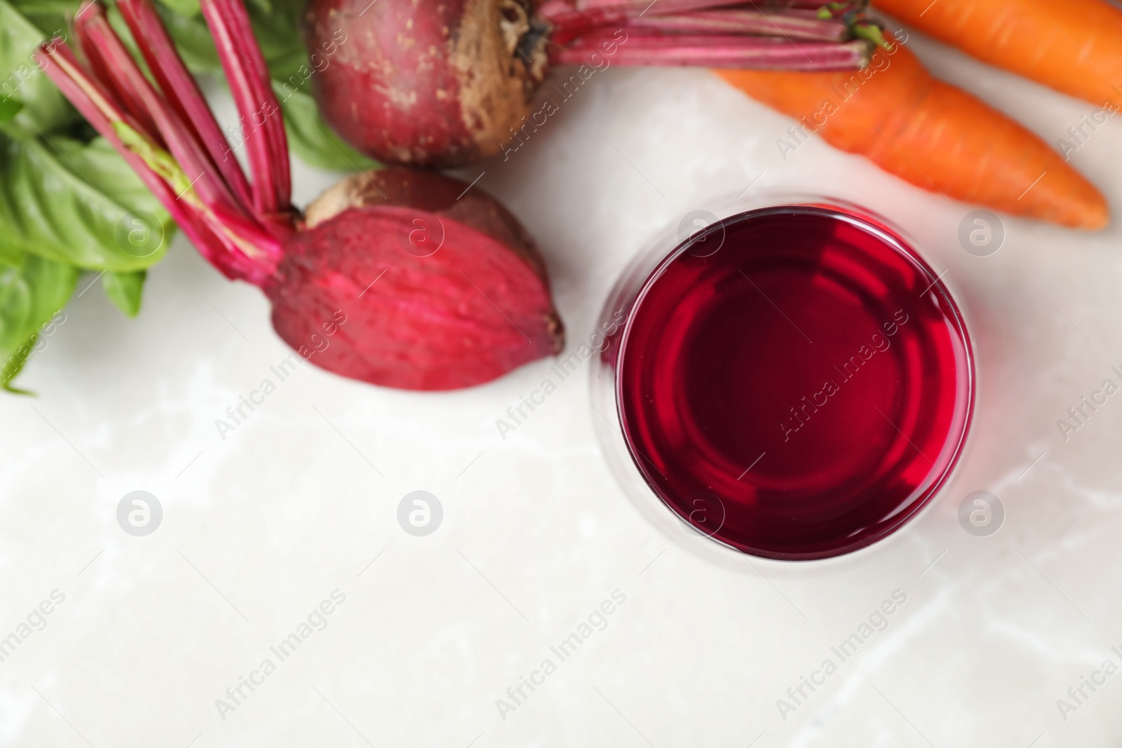 Photo of Glass with fresh beet juice and ingredients on table, top view