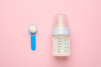 Photo of Feeding bottle with infant formula and powder on pink background, flat lay