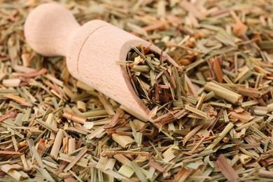 Photo of Wooden scoop and aromatic dried lemongrass, closeup