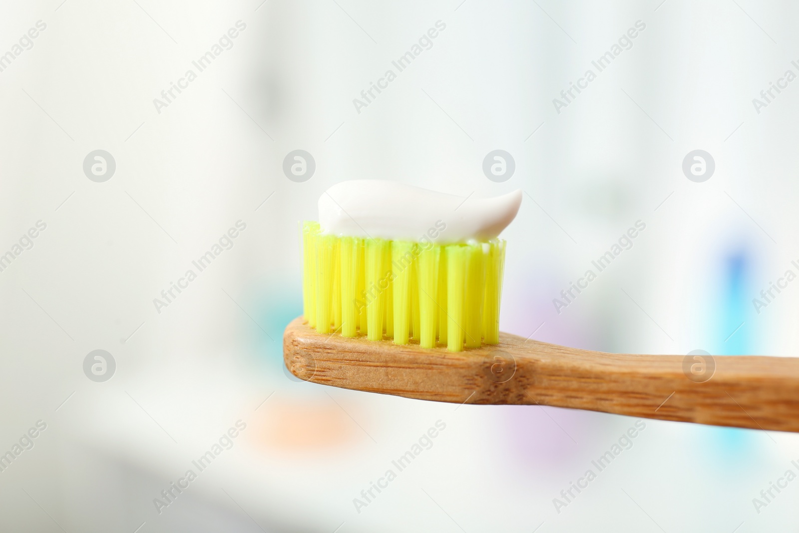 Photo of Brush with toothpaste on blurred background, closeup