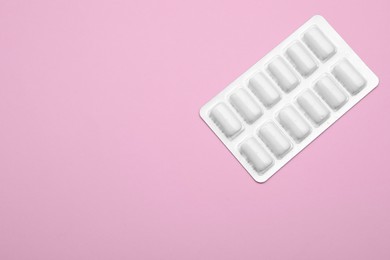 Blister with chewing gums on pink background, top view. Space for text