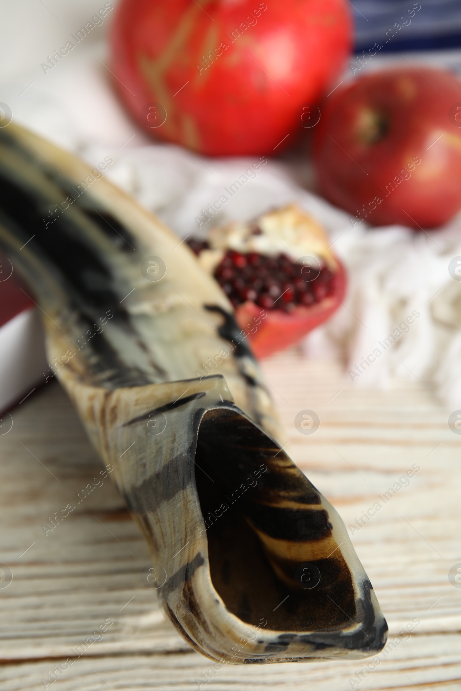 Photo of Shofar on white wooden table, closeup. Rosh Hashanah celebration