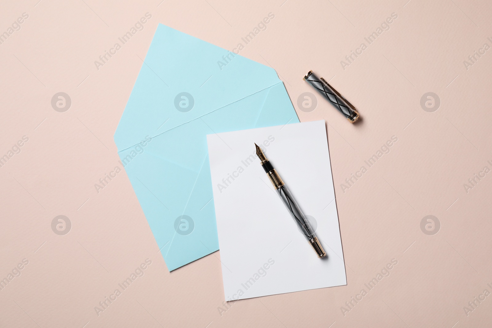 Photo of Blank sheet of paper, letter envelope and pen on beige background, top view