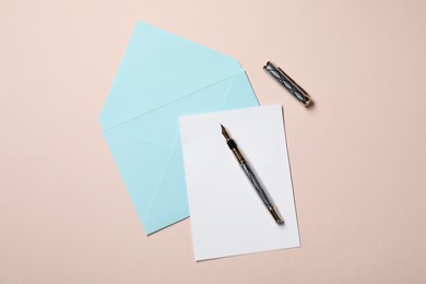 Photo of Blank sheet of paper, letter envelope and pen on beige background, top view