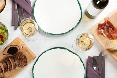 Photo of Delicious food and wine served for dinner on white wooden table, flat lay