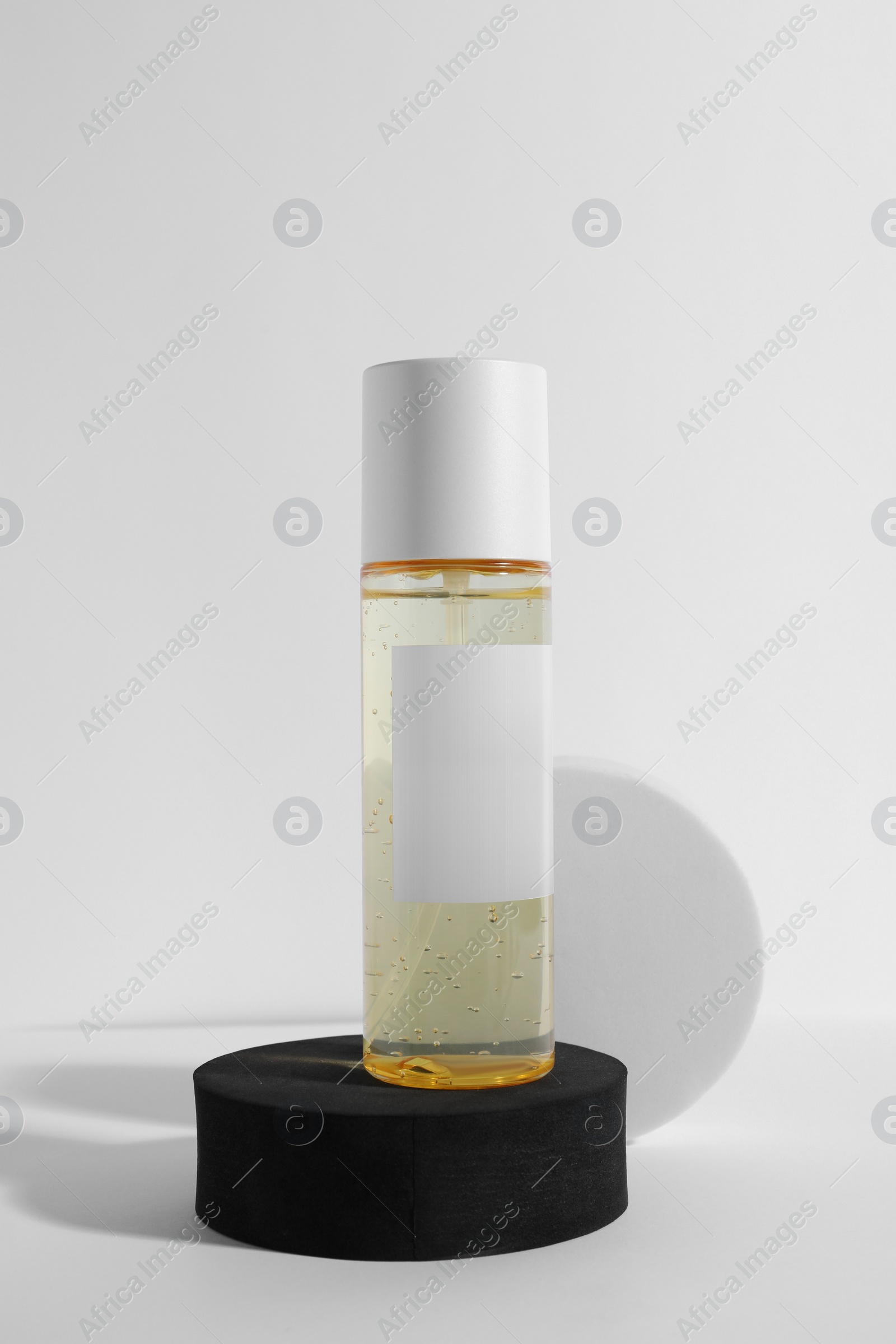 Photo of Bottle of cosmetic product and round podiums on white background