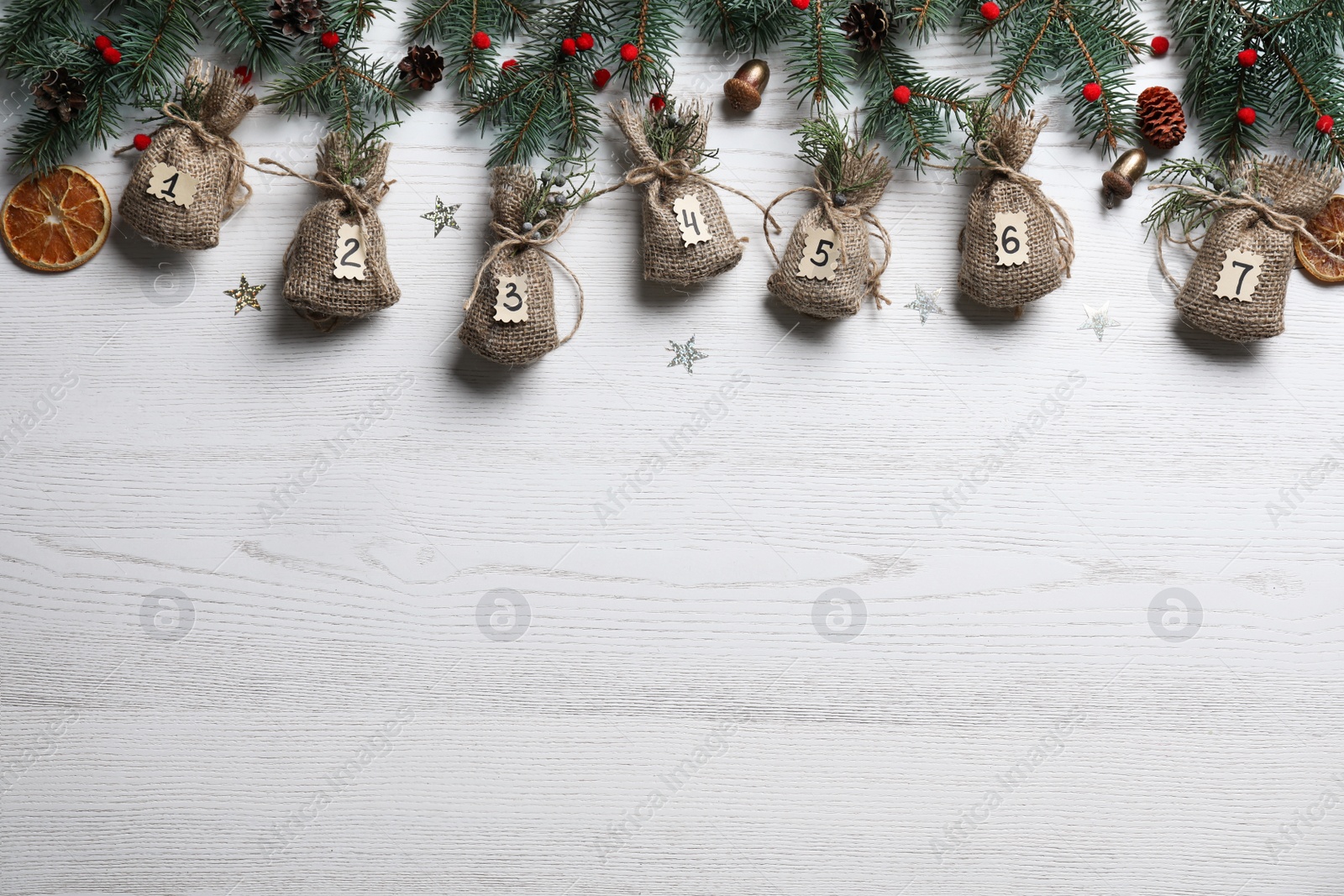 Photo of New Year advent calendar with gifts and Christmas decor on white wooden background, flat lay. Space for text