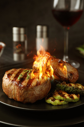 Image of Delicious grilled beef medallions with flame on plate