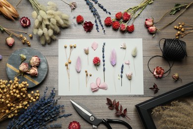 Flat lay composition with beautiful dry flowers on wooden background