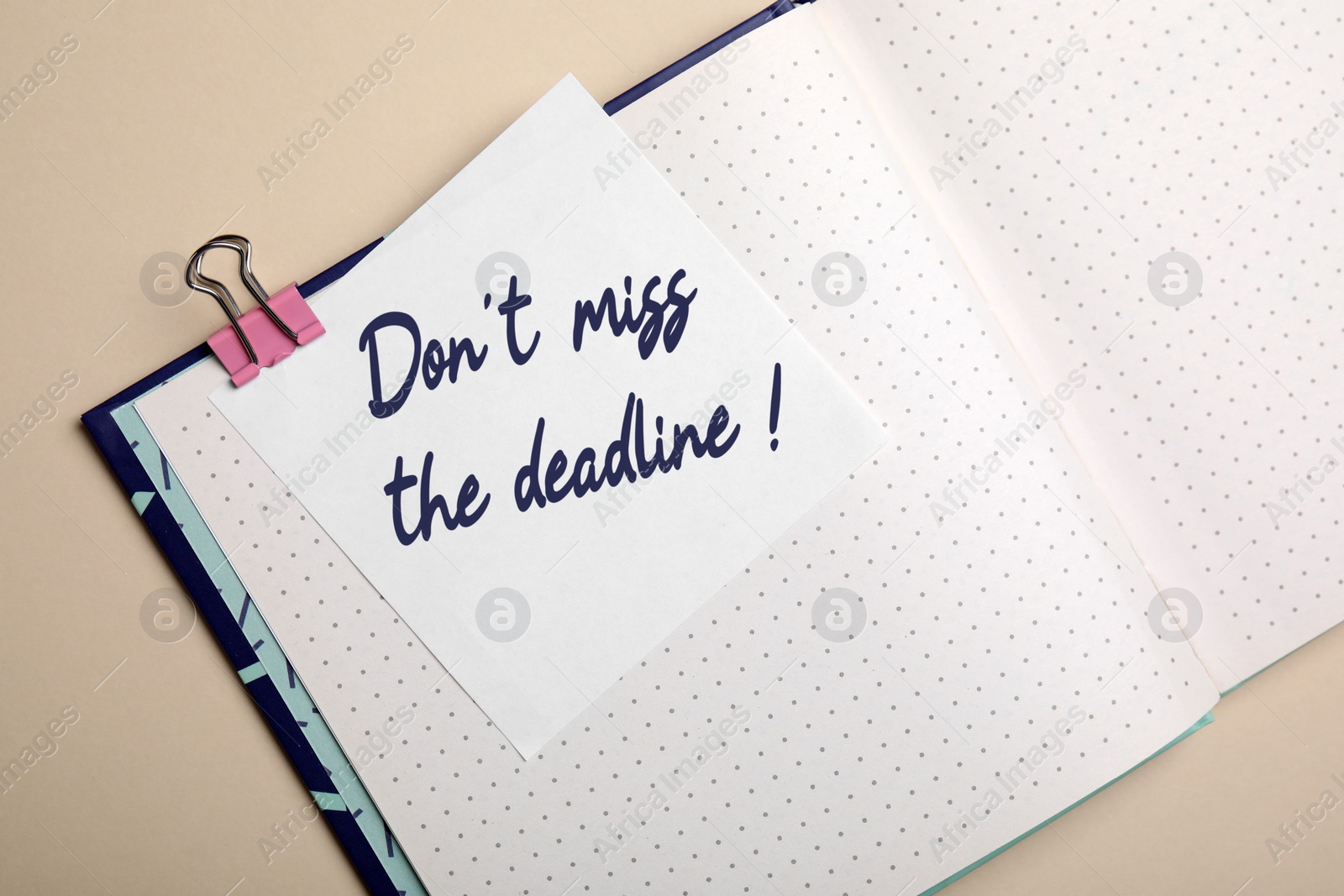 Image of Note with reminder Don't Miss The Deadline in notebook on beige background, top view