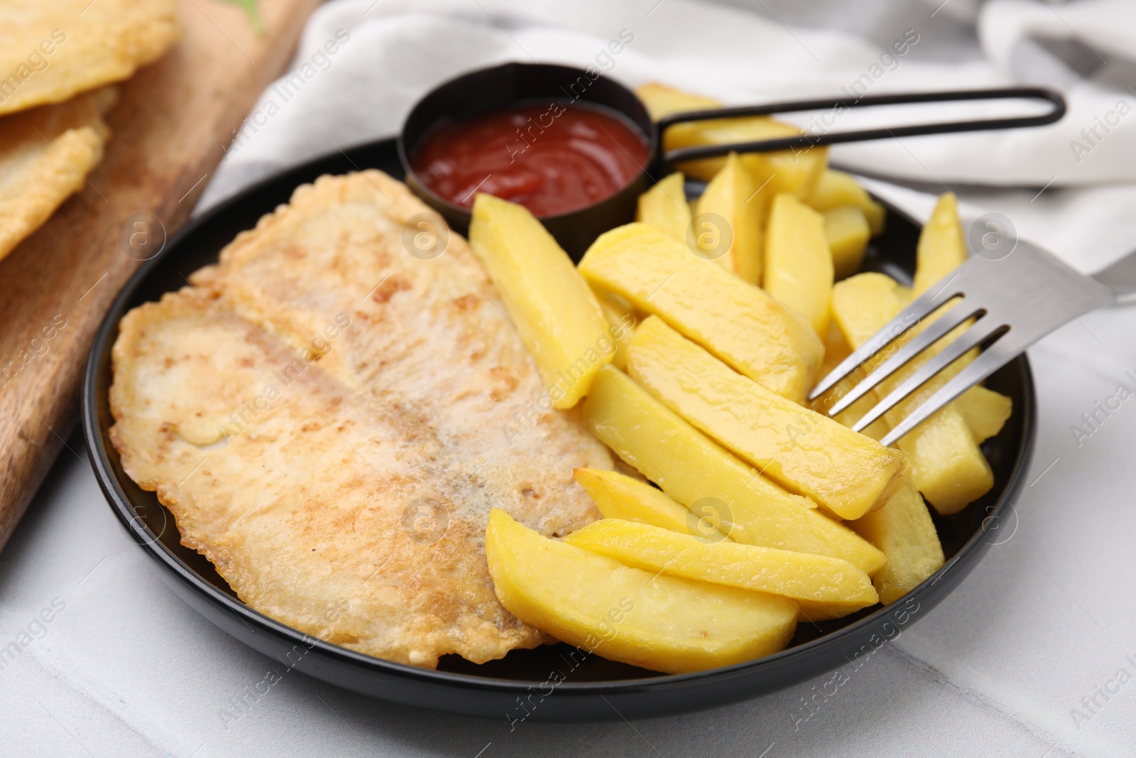 Photo of Delicious fish and chips served on white table, closeup