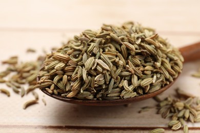 Photo of Spoon of fennel seeds on table, closeup