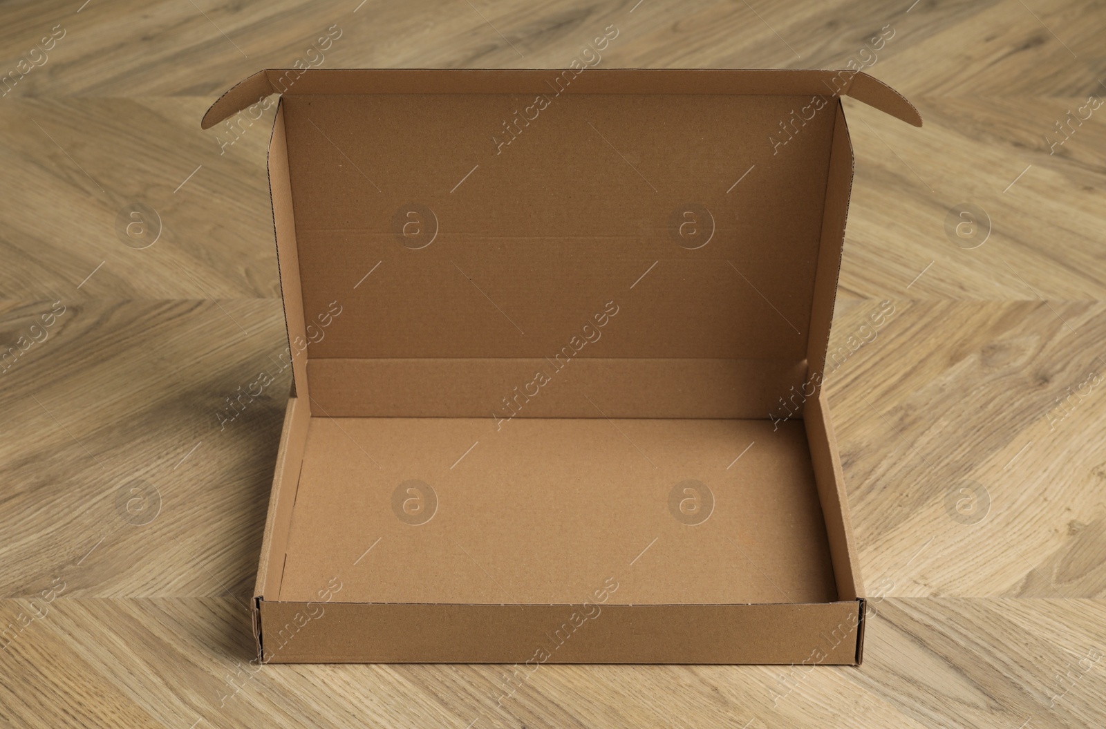 Photo of One empty open cardboard box on floor