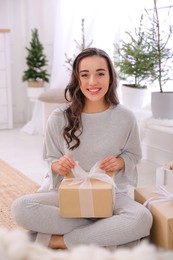 Photo of Woman with gift box on floor at home
