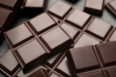 Photo of Delicious dark chocolate on black table, closeup