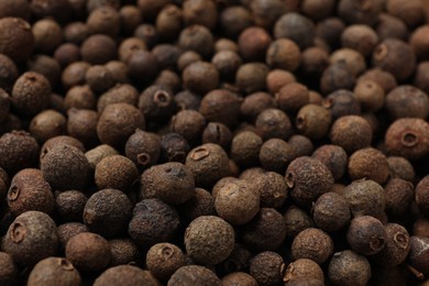 Photo of Aromatic allspice pepper grains as background, closeup view