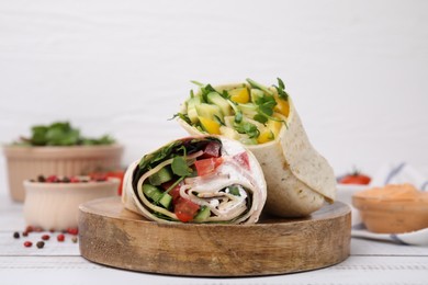 Delicious sandwich wraps with fresh vegetables and peppercorns on white wooden table