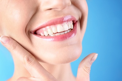 Photo of Young woman with healthy teeth and beautiful smile on color background, closeup