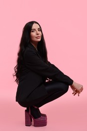 Photo of Stylish woman in black jacket on pink background