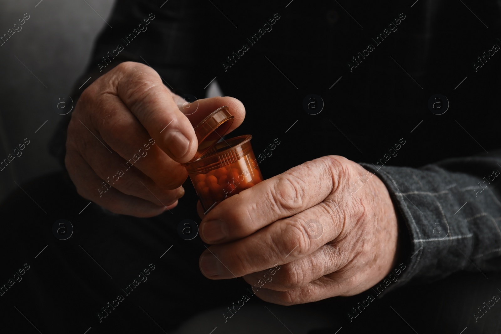 Photo of Senior man holding bottle with pills, closeup of hands