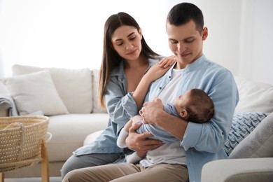 Happy family with cute baby on sofa at home