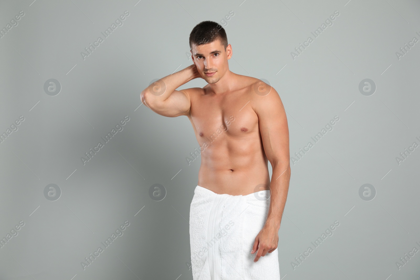 Photo of Young man with slim body on grey background