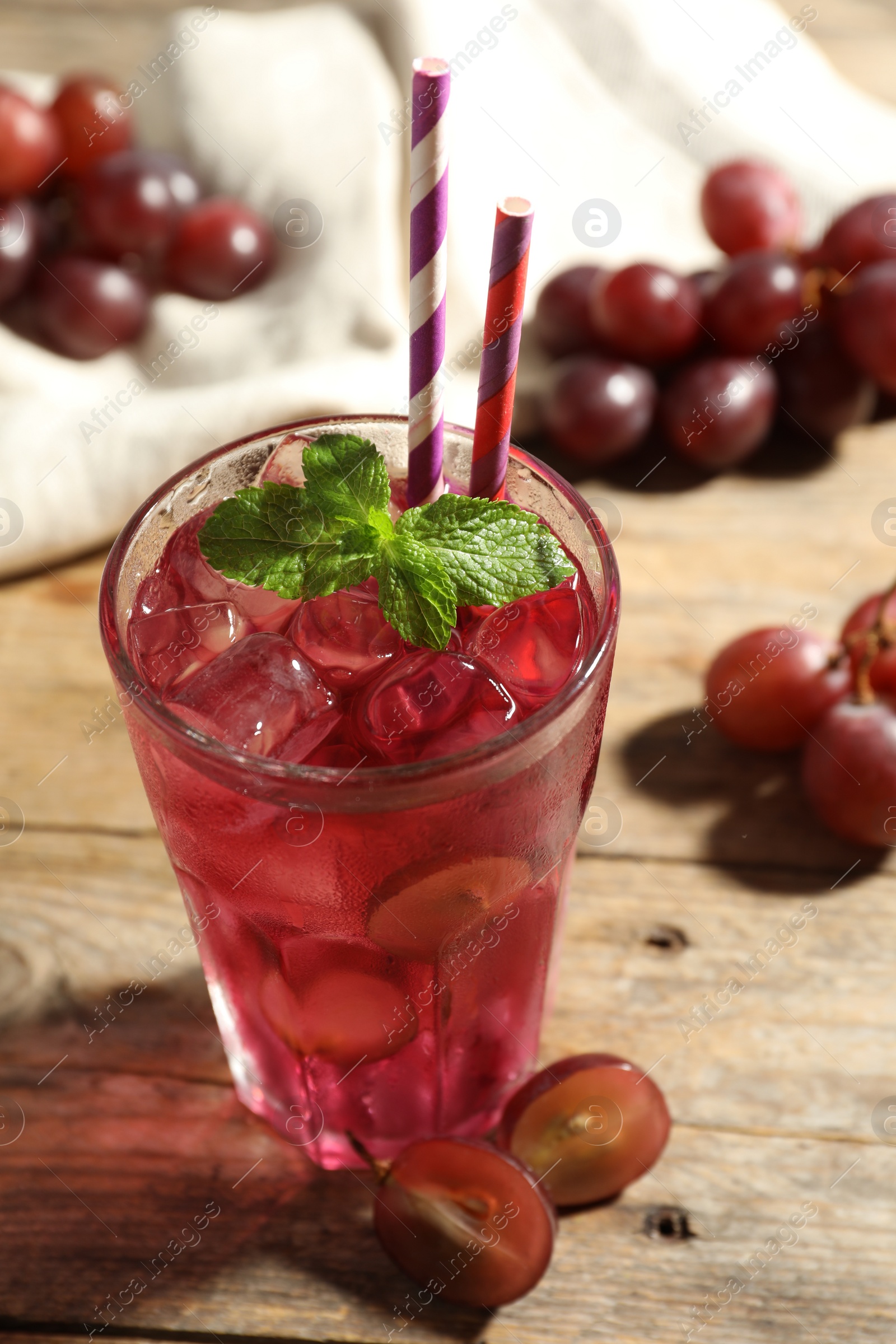 Photo of Delicious grape soda water with mint and berries on wooden table. Refreshing drink