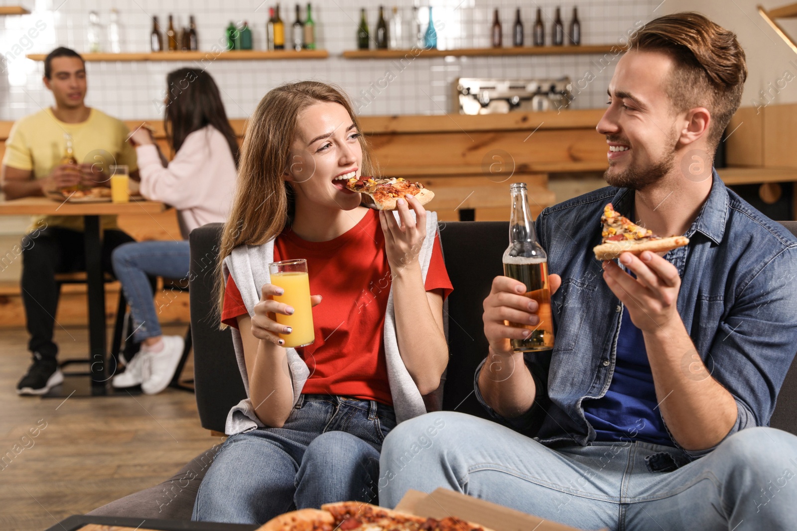 Photo of Young couple eating delicious pizza in cafe