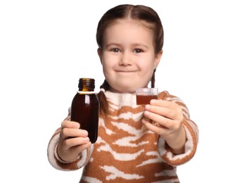 Photo of Cute girl showing cough syrup on white background, focus on hands. Effective medicine