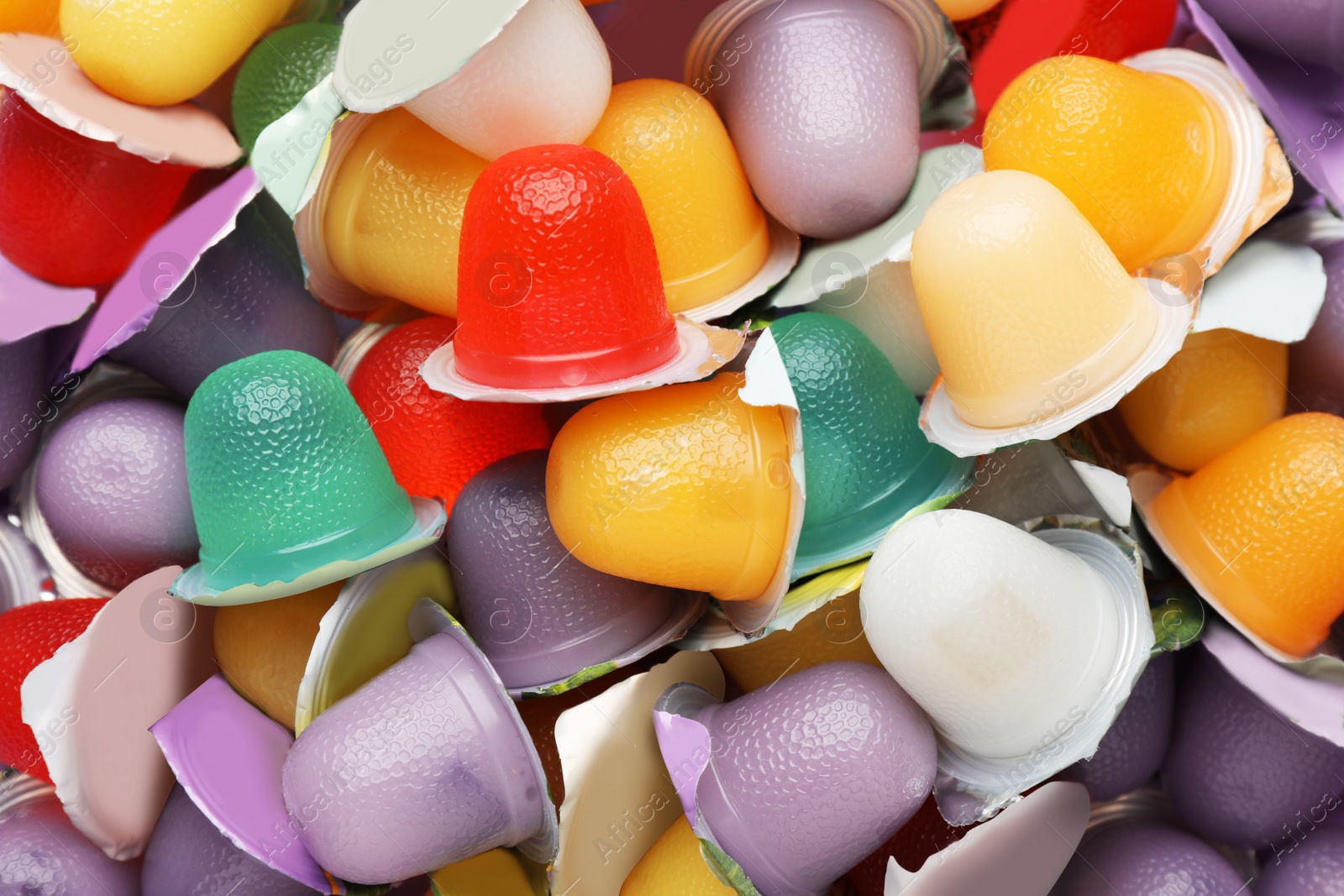 Photo of Tasty bright jelly cups as background, top view