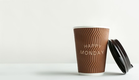 Image of Happy Monday. Takeaway paper coffee cup and lid on white background, space for text