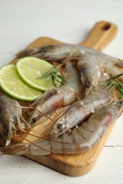 Photo of Fresh raw shrimps on white wooden table, closeup