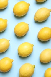 Many fresh ripe lemons on light blue background, flat lay