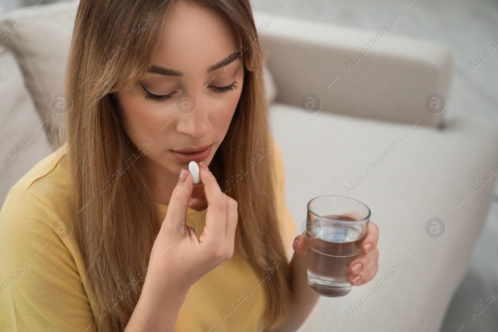 Photo of Young woman taking abortion pill at home