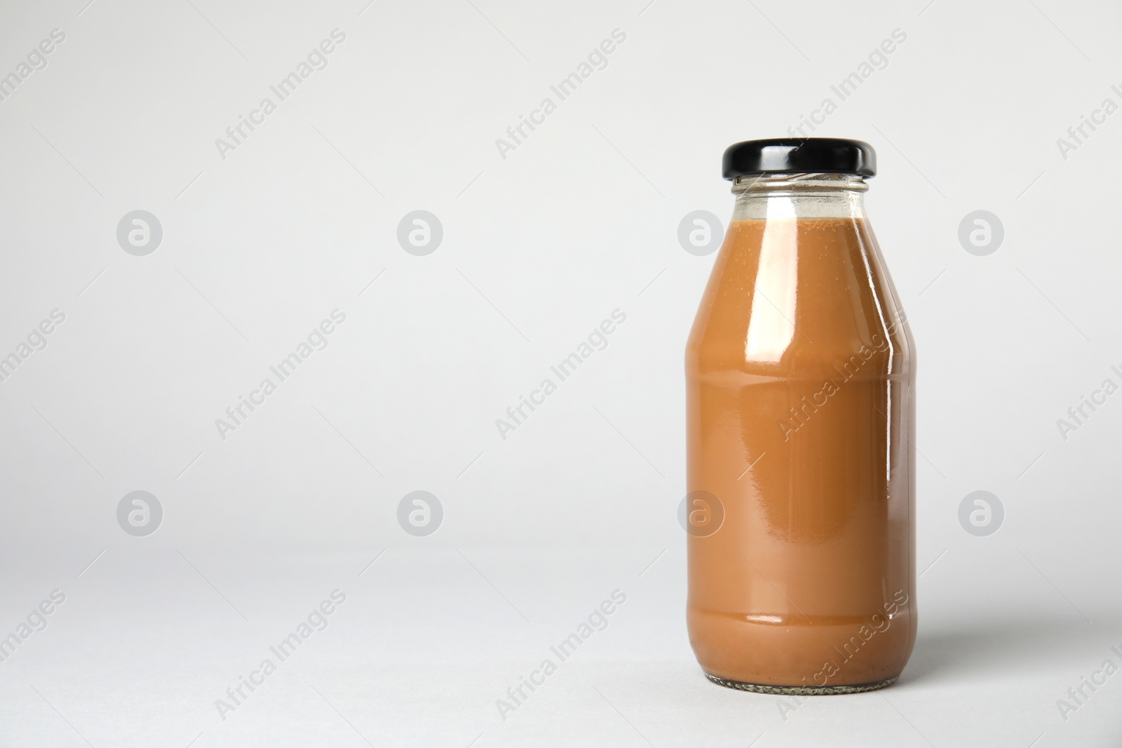 Photo of One bottle with tasty drink on color background. Space for text