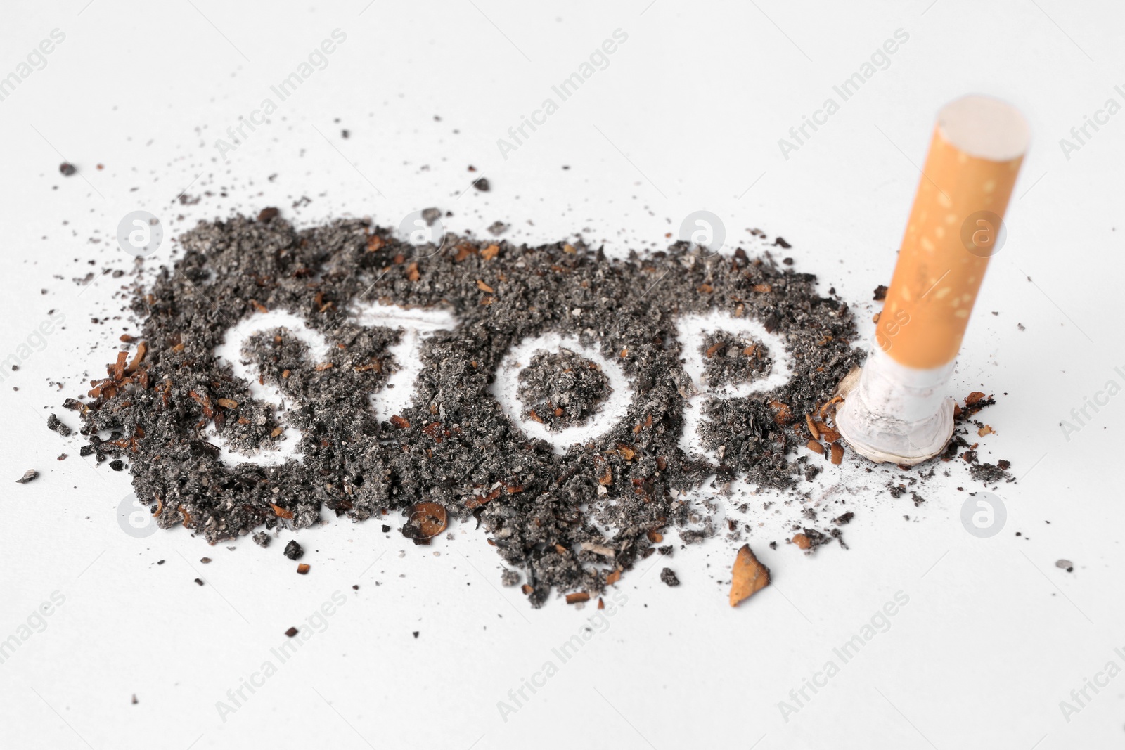 Photo of Word Stop made of cigarette ash and stub on white background, closeup. Quitting smoking concept