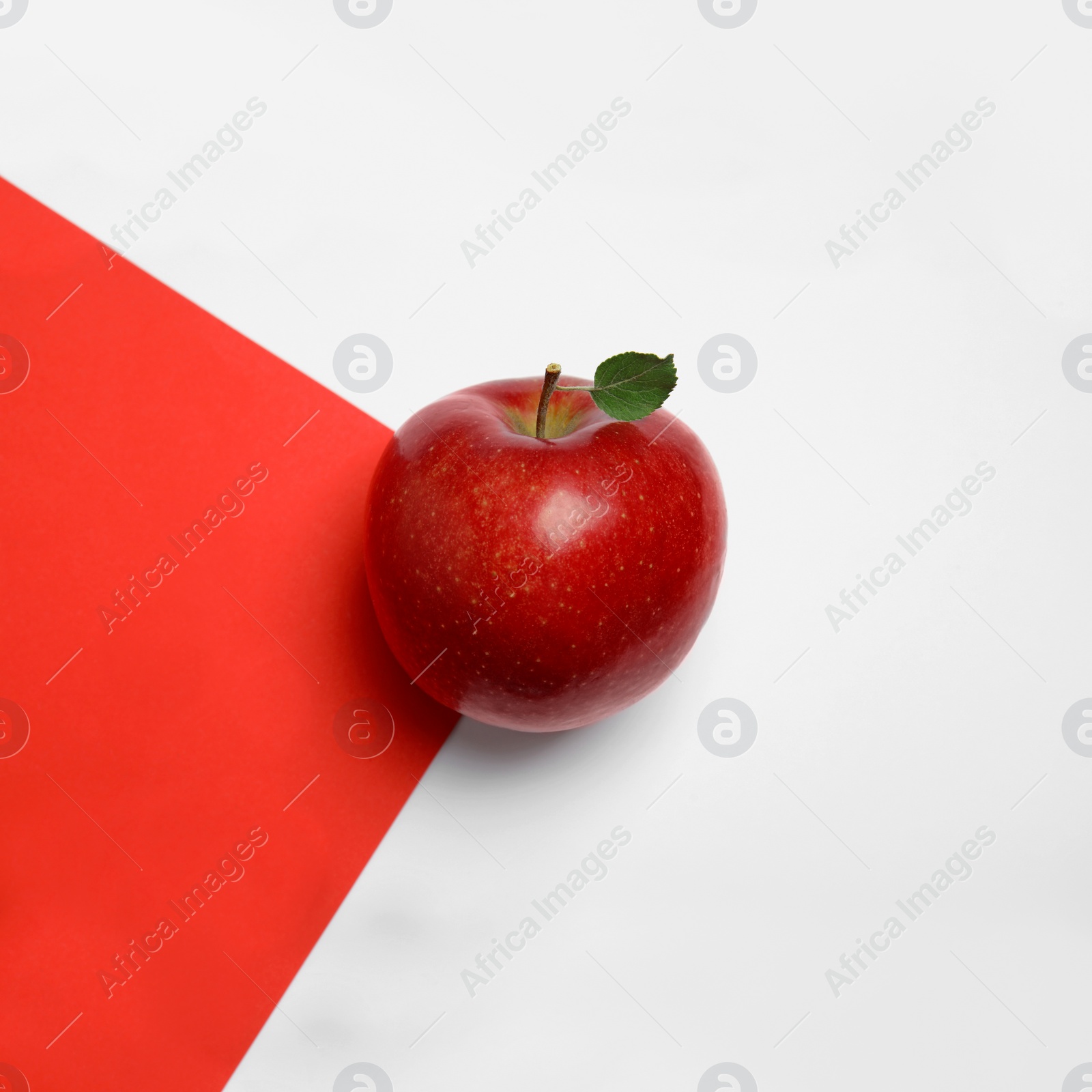 Photo of Ripe juicy red apple with leaf on color background, top view