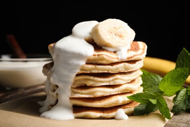 Photo of Tasty pancakes with sliced banana served on table, closeup