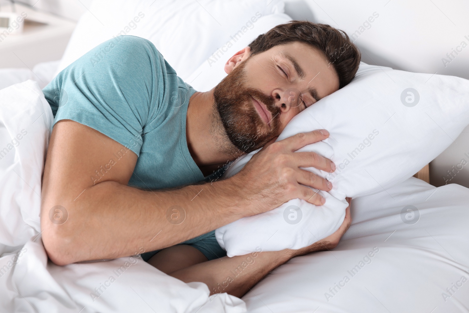 Photo of Man sleeping on comfortable pillows in bed at home