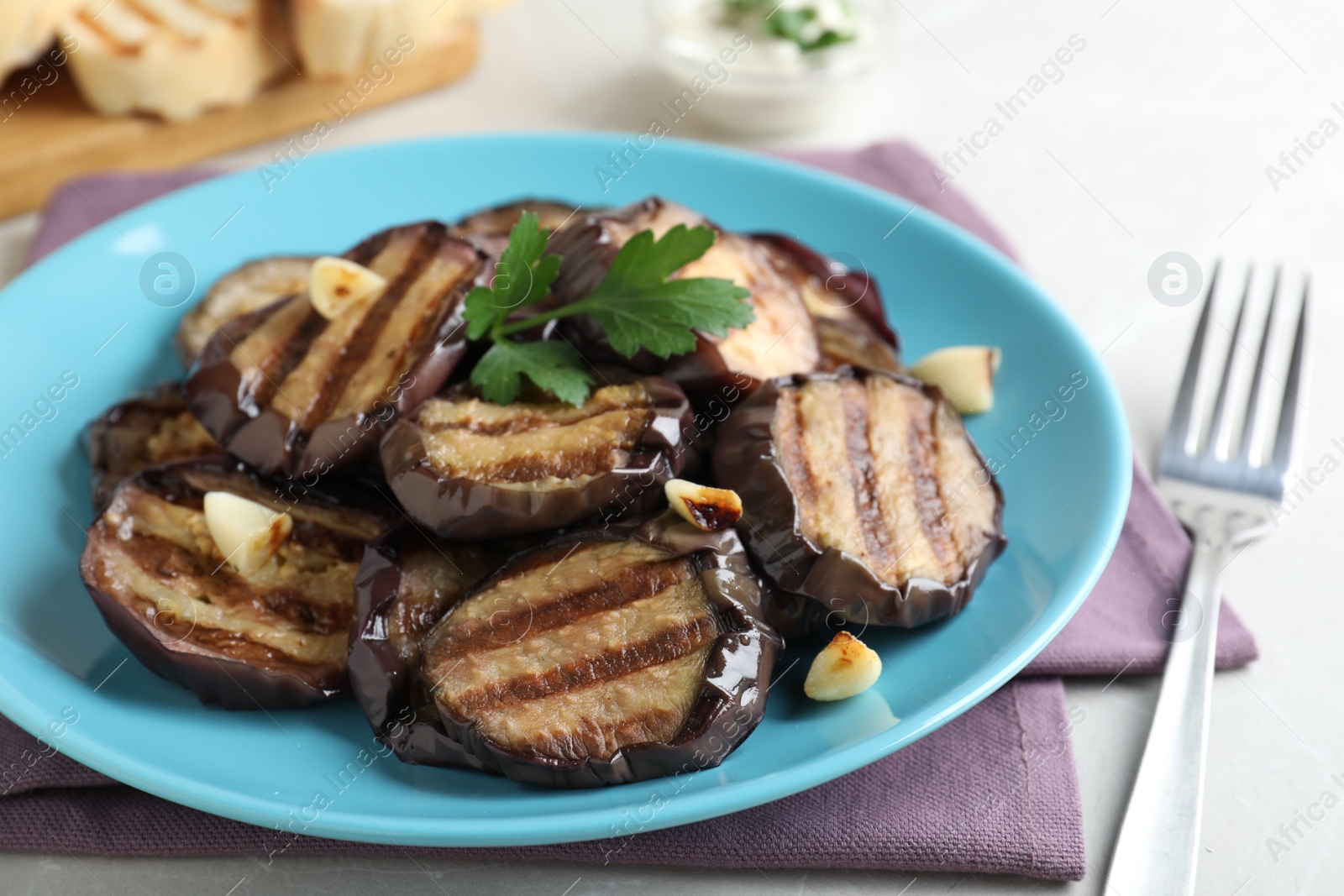 Photo of Delicious grilled eggplant slices served on table, closeup
